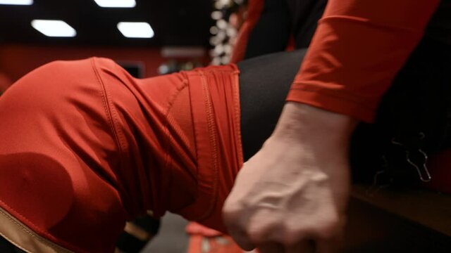 Hockey player putting on uniform. Action. Close-up of athlete putting on uniform and protection on feet. Hockey player puts on uniform in locker room