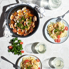 Mediterranean cuisine: pasta with seafood, with vongole. Italian lunch. Lifestal mood. Light background, top view