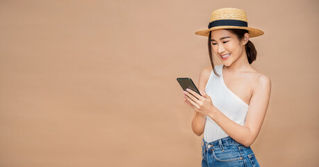 Portrait of beautiful Asian Japanese successful tourist girl celebrate with smartphone with copy...