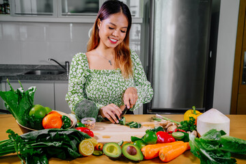 Asian girl cooking healthy vegetarian and vegan food, vegetables and fruits in the kitchen, healthy lifestyle