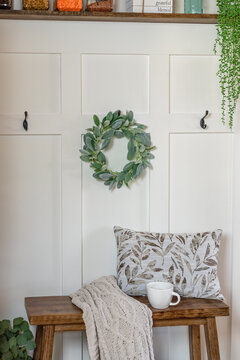 Board and batten accent wall with a small decorative bench