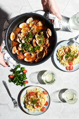 Mediterranean cuisine: pasta with seafood, with vongole. Italian lunch. Lifestal mood. Light background, top view