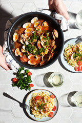 Mediterranean cuisine: pasta with seafood, with vongole. Italian lunch. Lifestal mood. Light background, top view