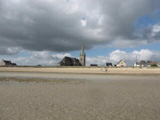 the skyline of fontenay sur mer at the beautiful french coast with a broad sand beach with low tide in normandy in summer