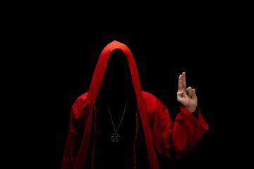 Mystery man in a red hooded cloak in the dark. Unrecognizable person. Hiding face in shadow....