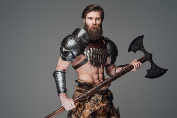 Warlike nordic warrior with nude and muscular body posing with an axe