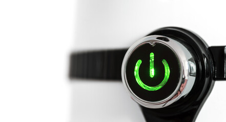 Power button with green light on a white background with a black stripe