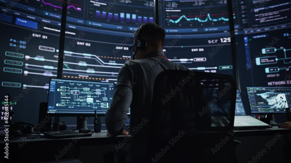 Aufkleber Professional IT Technical Support Specialist and Software Developer Working on Computer in Monitoring Control Room with Digital Screens. Employee Wears Headphones with Mic and Talking on a Call.