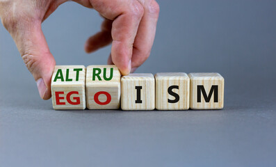 Altruism or egoism symbol. Businessman turns wooden cubes and changes the word 'egoism' to...