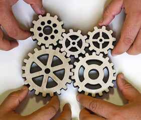 hand hold set of five different wooden cog wheels isolated on white background.