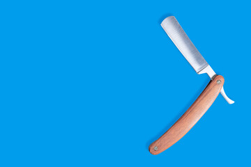 Straight metal razor with a wooden handle.