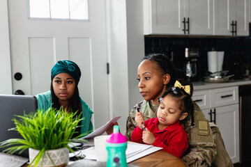 Black family paying bills at home, soldier