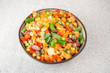 Assorted frozen vegetables in a plate. Semi-finished vegetable mix for instant cooking. Food concept.