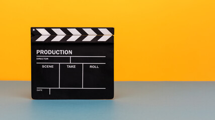 Filmmaker profession. Clapperboard on yellow and teal blue background
