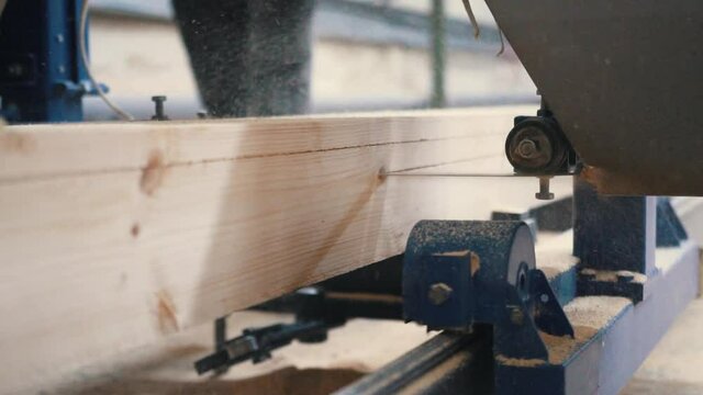 Production of laminated veneer lumber on plant on cutting machine equipment. The production line for wood. Woodworking timber industry: machinery and equipment for press and cutting of lumber.