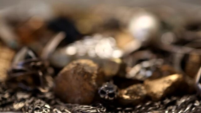 Pile of silver and gold jewelry with jewels rotating macro