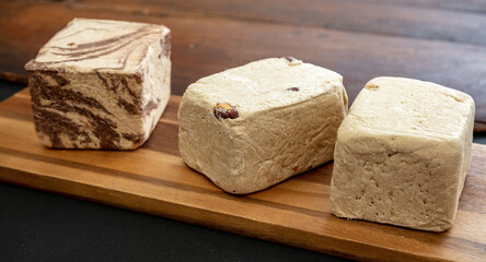 Halva almond nuts and cocoa pieces on wooden table background