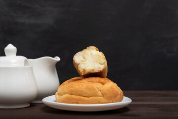 Eclairs with butter cream on serving plate. Baking for tea. Traditional french dessert