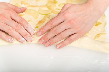 Naklejka premium Hands of chef prepares an apple dessert. Apple pie making process