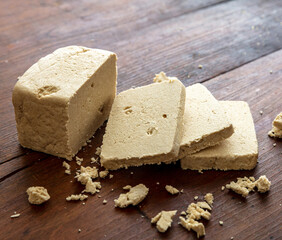 Halva vanilla slices on wooden table background, closeup view.