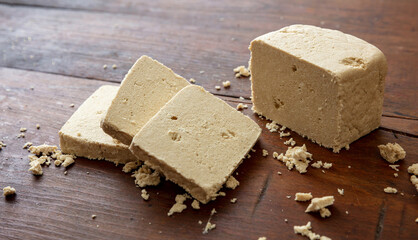 Halva vanilla slices on wooden table background, closeup view.