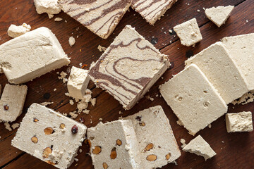 Halva almond nuts and cocoa slices on wooden table background