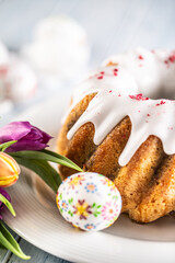 Festive easter marble cake with icing sugar hand-decorated eggs and spring tulips