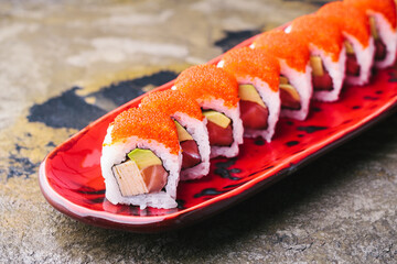 Salmon sushi rolls on red plate. Alaska rolls.