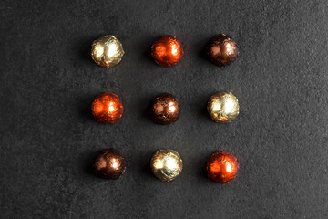 Chocolate candies wrapped in colorful foil on dark background