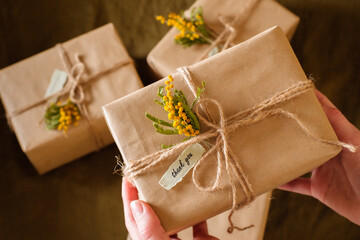 female hands holding gift boxes decorated with yellow flowers a thank you. Appreciate Concept. top...