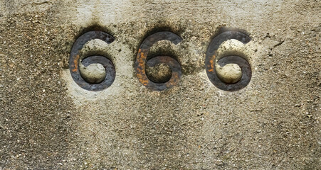 Engraved number 666 on stone background. iron digits, numbers - three six.