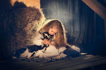 Beautiful little girl with long hair with a little lamb in the hayloft in Russia. Image with selective focus and toning © Smolina