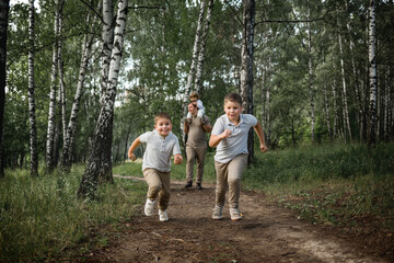 Two elder boys are running a race, their parents and younger brother are cheering for them. Image...