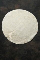 Round pita bread on a dark background top view with copy space.