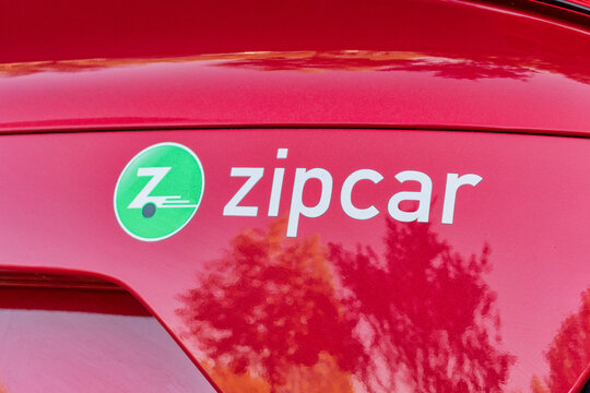 Zipcar car sharing and car club service logo on side of red rental car. Zipcar is a subsidiary of Avis Budget Group. - San Francisco, California, USA - 2021