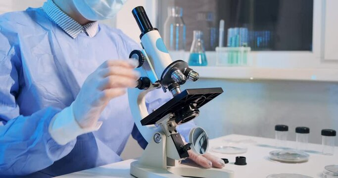 Close-up of female scientist working with microscope. Laboratory modern minimalist clinic environment indoor. Vaccine and covid-19 virus research. Stock market news technology coronavirus treatment