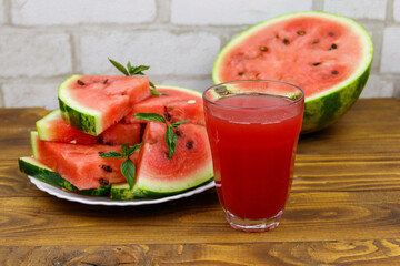 Glass of fresh watermelon juice on a wooden table