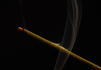 scented sticks and smoke on black background