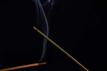 scented sticks and smoke on black background