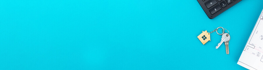 Buying a house or mortgage concept banner. Model toy house with shopping cart on blue background. Housing and Real Estate concept.