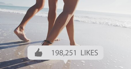 Animation of speech bubble with thumbs up icon and numbers, low section of couple walking on beach - Powered by Adobe
