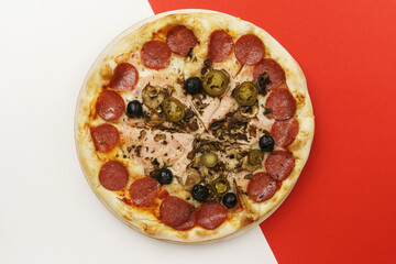 Not a perfect pizza. Pizza with salami, mushrooms, olives. White-red background