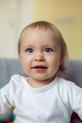 girl child sits in a pool with colorful plastic balls