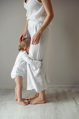 mom and daughter are standing at the window wall