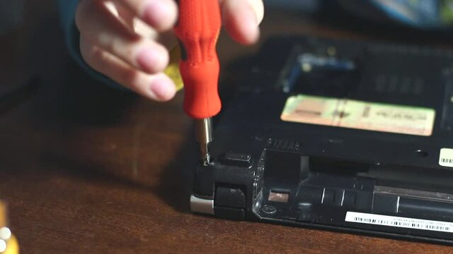 Child disassembles laptop close up