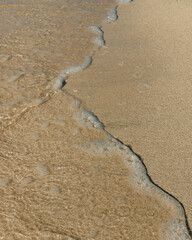Fototapeta na wymiar Wave on the beach with bubbles