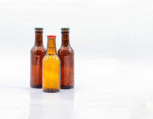 THREE COLD BROWN GLASS BEER BOTTLES WITH METAL PLATE CAP