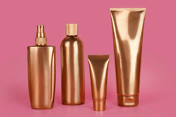 Golden bottles, cosmetic products on pink background. Luxury beauty style. Gold cosmetic...