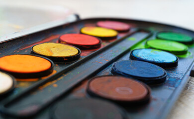 Colors on watercolor palette closeup. Selective focus.