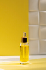 cosmetic serum and natural cosmetic oil in glass bottles on a yellow background. Skin beauty and health concept.